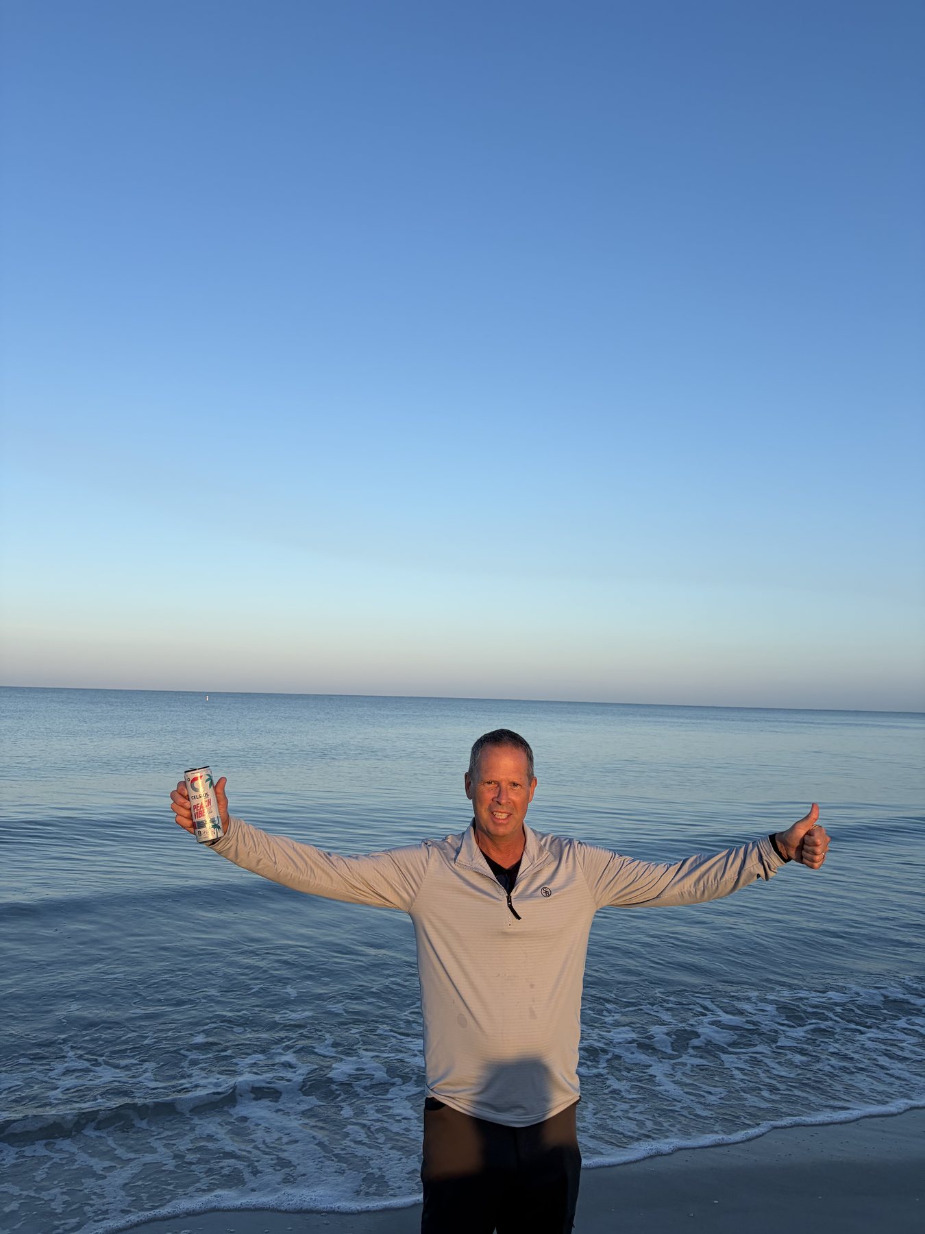 Charlie Hough on the beach at sunset, arms wide, unfiltered and free.
